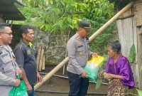 Kapolsek Ndona, IPTU I Gede Wisna Didampingi Anggota, Menyerahkan Bingkisan Sembako Ke Salah Satu Warga/Foto: FD