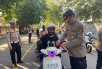 Pembagian bendera merah putih kepada pengendara oleh Kapolres Ende. Kamis (7/08). Sumber foto: Humas Polres Ende. 